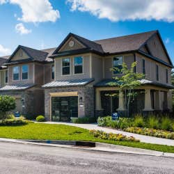 Greens of Scherwood light brown townhomes under bright blue sky